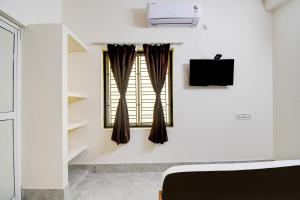 a room with a window and a tv at OYO ALYSAN STAY in Bhubaneshwar
