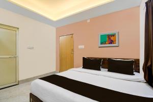 a bedroom with a large bed with black pillows at OYO ALYSAN STAY in Bhubaneshwar