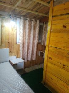 um quarto com uma cama e uma parede de madeira em Green Island Nature Stay em Seringapatam