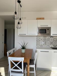 a kitchen with a wooden table and white cabinets at The Tulip: 2 rooms apartment in Ronzo Chienis