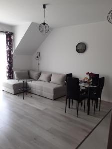 ein Wohnzimmer mit einem Sofa und einem Tisch in der Unterkunft Apartament w Starym Młynie in Sobótka