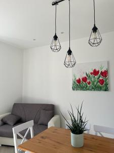 a living room with a table and a painting of red flowers at The Tulip: 2 rooms apartment in Ronzo Chienis
