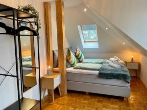 Dormitorio pequeño con cama en el ático en Villa Ambiente Falkensee en Falkensee