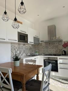 a kitchen with a wooden table and white cabinets at The Tulip: 2 rooms apartment in Ronzo Chienis