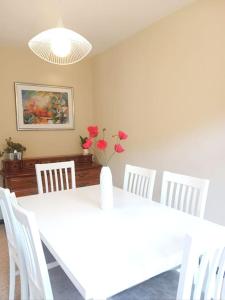 a white dining room with a white table and white chairs at Casa Calvo in Viveiro