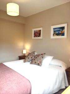 a bedroom with a large white bed with two pillows at Casa Calvo in Vivero