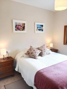 a bedroom with a bed and two pictures on the wall at Casa Calvo in Vivero