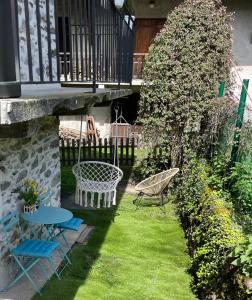 La Tour charmant studio très bien situé في Tours-en-Savoie: حديقة بها طاولة وكراسي وشرفة