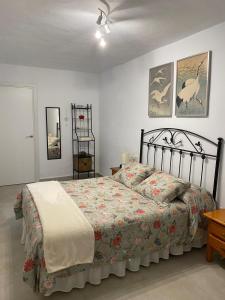 a bedroom with a large bed with a floral bedspread at La Casa Rosales in Alora