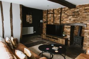 a living room with a couch and a flat screen tv at Cobblers Cottage Brigg in Brigg