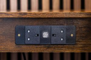 バーミンガムにあるChic Studio in the Heart of Birmingham's Jewellery Quarterの木製のベンチの上の黒い電気コンセント