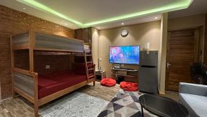 a living room with a large tv and a couch at THE YARD, DUONG DONG, PHU QUOC in Phu Quoc