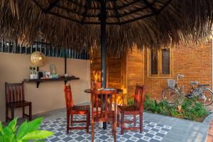 a table and chairs under a straw umbrella at THE YARD, DUONG DONG, PHU QUOC in Phu Quoc