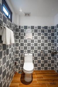 a bathroom with a toilet and a tiled wall at THE YARD, DUONG DONG, PHU QUOC in Phu Quoc +56 photos