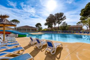 une piscine avec des chaises et un toboggan dans l'établissement Maison - Residence avec piscine, à Calvisson