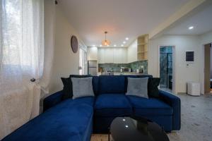 Una sala de estar con un sofá azul y una cocina. en Peaceful Private Bungalow VIPGreece, en Atenas