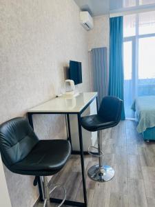 una camera con un tavolo, due sedie e un letto di Panorama a Batumi