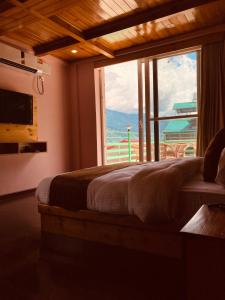 a bedroom with a bed and a large window at Saksham INN in Jaipur