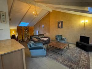 a living room with a couch and chairs and a table at La Gandonne in Caderousse