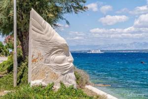 a statue of a face next to the water at Sunny Apartment in Kali