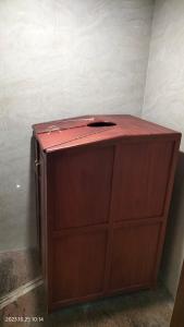 a wooden cabinet with a red top in a room at EZHIMALA AYURVEDA AND WELLNESS RESORT in Payyannūr