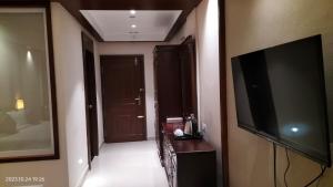 a room with a flat screen tv and a hallway at EZHIMALA AYURVEDA AND WELLNESS RESORT in Payyannūr