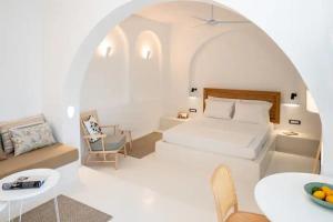 Habitación blanca con cama, mesa y silla en Piccole Case en Kamari