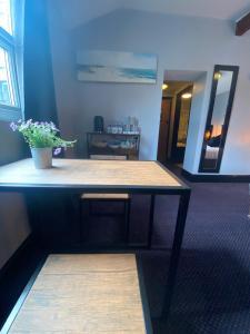 Una mesa en una habitación con una maceta. en Bay view rooms at Mentone Hotel, en Weston-super-Mare