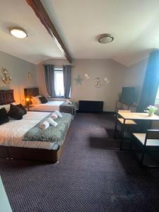 a hotel room with two beds and a table at Bay view rooms at Mentone Hotel in Weston-super-Mare