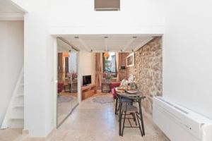 uma sala de estar com uma mesa e uma parede de pedra em LE PETIT MARCHE - NEW 2021 Fabuleux studio 2Pax Wi-fi A/C em Antibes