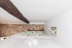 um quarto com uma cama branca e toalhas em LE PETIT MARCHE - NEW 2021 Fabuleux studio 2Pax Wi-fi A/C em Antibes