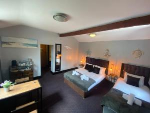 Habitación de hotel con 2 camas y espejo en Bay view rooms at Mentone Hotel, en Weston-super-Mare