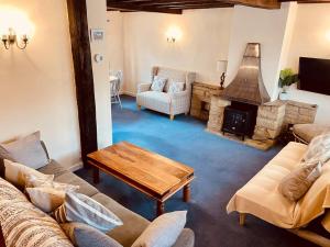 a living room with a couch and a fireplace at Bewdley Central - Sandy Bank Cottage in Bewdley