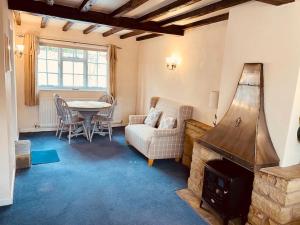 a living room with a couch a table and a fireplace at Bewdley Central - Sandy Bank Cottage in Bewdley