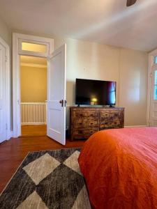 1 dormitorio con 1 cama y TV de pantalla plana en Historic Home in Washington DC w Hot Tub & Parking, en Washington