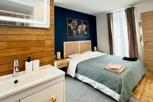 1 dormitorio con 1 cama grande y lavamanos en Airbnb à Paris-Bois de Vincennes en Saint-Maurice