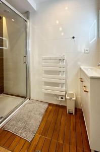 a bathroom with a shower and a wooden floor at Airbnb à Paris-Bois de Vincennes in Saint-Maurice