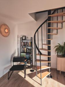 a spiral staircase in a living room with a book shelf at Nomads' Hill in Poraż