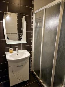 een badkamer met douche, wastafel en spiegel bij Дом Крумови in Boergas