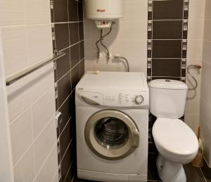 een kleine badkamer met een wasmachine en een toilet bij Дом Крумови in Boergas