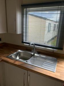 a kitchen sink with a window in a kitchen at Newbeach Holiday Park - Greenfields in Dymchurch