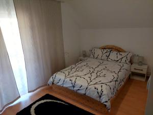een slaapkamer met een bed met een zwart-wit dekbed bij Casa Mario 2 in Oradea