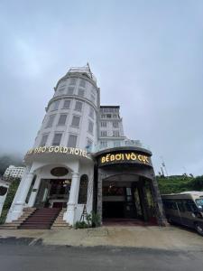 un bâtiment blanc avec un panneau à l'avant dans l'établissement Tam Đảo Gold Hotel, à Tam Ðảo