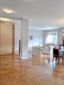 sala de estar con muebles blancos y suelo de madera en The Boutique Houses Milan - Luxury collection, en Milán