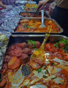 a buffet line of trays of food with a spoon at Kylie magic camp in Wadi Rum