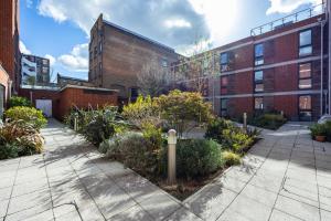 une cour dans un bâtiment avec des plantes et des bâtiments dans l'établissement Modern 1 BR Apartment Near Shoreditch - 10 Min Walk, à Londres