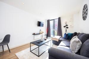- un salon avec un canapé et une table dans l'établissement Modern 1 BR Apartment Near Shoreditch - 10 Min Walk, à Londres