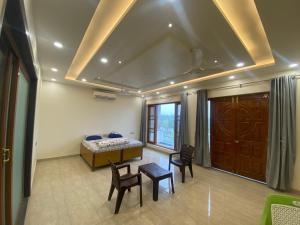 1 dormitorio con 1 cama, 2 sillas y mesa en Paradise rooms en Lucknow