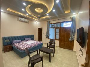 a bedroom with a bed and a table and chairs at Paradise rooms in Lucknow