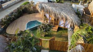 an overhead view of a house with a thatched roof at JERUSALEMA BEACH GLAMPING in Tolú